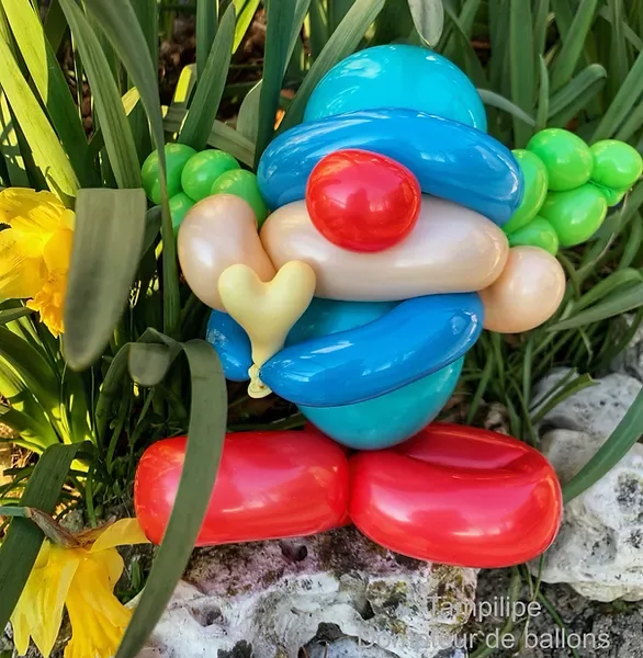 Sculpture en ballons d&rsquo;un clown allong&eacute; dans l&rsquo;herbe