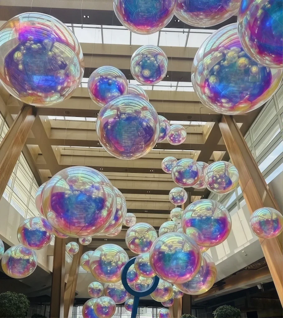 Grands ballons bulles iris&eacute;s remplissant un atrium &agrave; verri&egrave;re